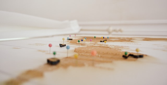 A sandy map with colourful pins.
